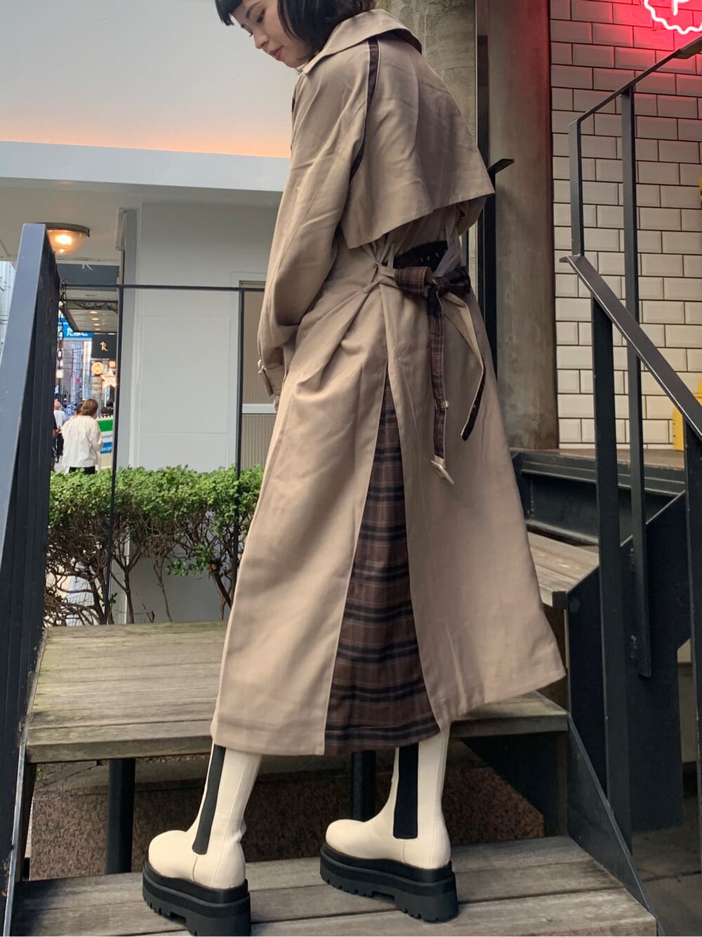 ベージュ系のトレンチコート、ブラック系のワンピースを着用したレディースの夏コーディネートの4枚目の写真