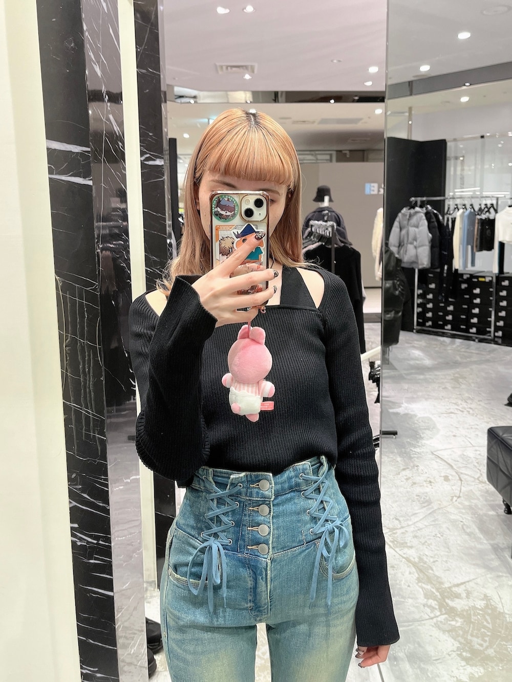 ブラック系のニット/セーター、ブルー系のデニムパンツ、ブラック系のブーツを着用したレディースの冬コーディネートの2枚目の写真