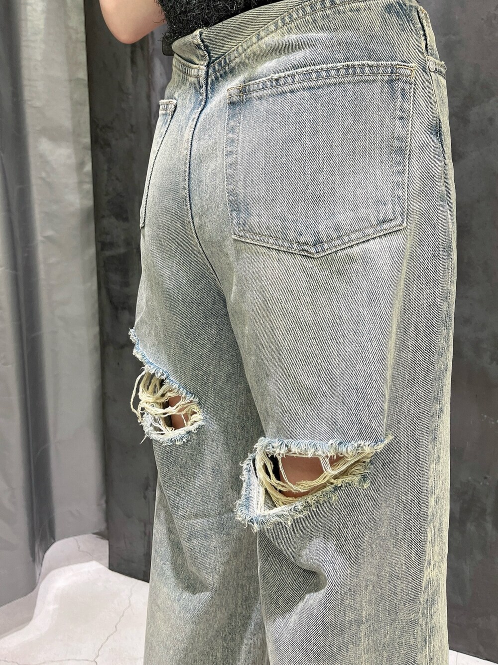 ブルー系のデニムパンツ、ブラック系のサンダル、グレー系のタンクトップを着用したレディースの夏コーディネートの6枚目の写真