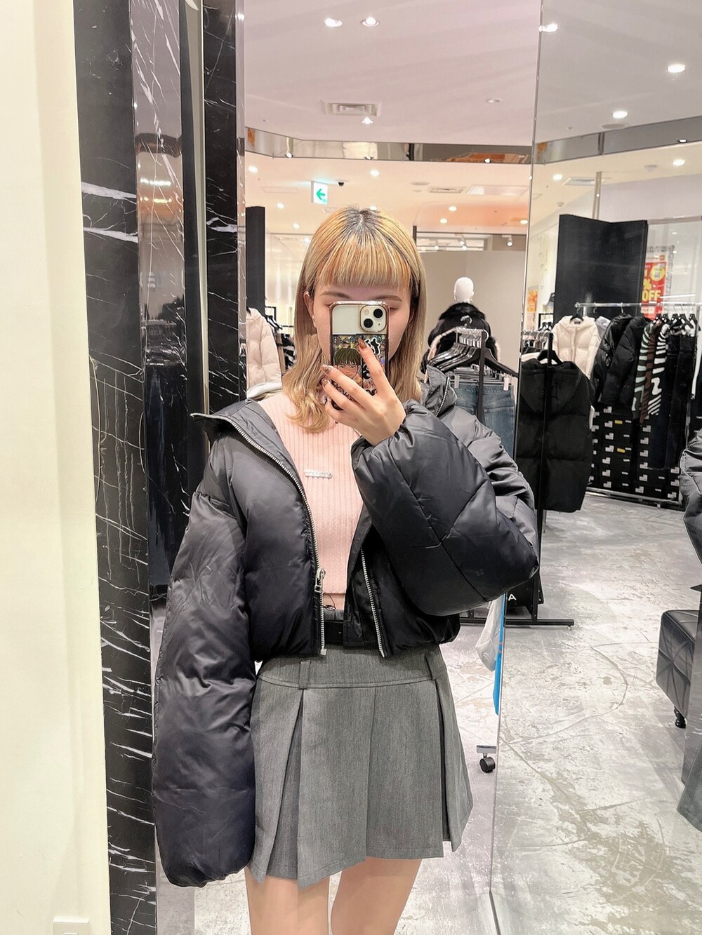 ピンク系のニット/セーター、ブラック系のダウンジャケット/コートを着用したレディースの冬コーディネートの2枚目の写真