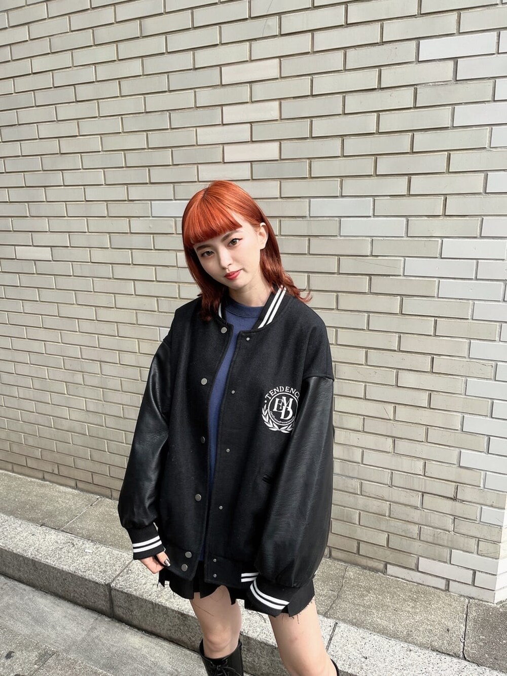 ブラック系のスカート、ブルー系のスウェット、ブラック系のブルゾンを着用したレディースの秋コーディネートの2枚目の写真