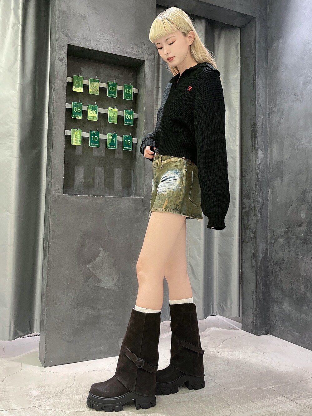 ブラック系のニット/セーター、ブラウン系のスカート、ブラック系のブーツを着用したレディースの冬コーディネートの2枚目の写真