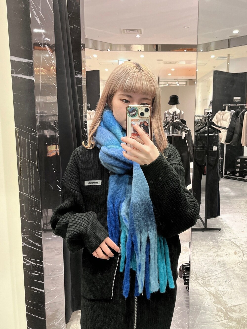 ブラック系のスカート、ブラック系のニット/セーター、ブラック系のブーツを着用したレディースの秋コーディネートの2枚目の写真