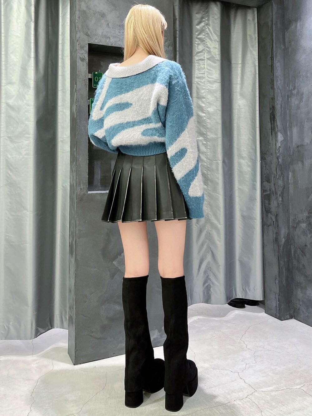 ブラック系のスカート、ブラック系のブーツ、グレー系のニット/セーターを着用したレディースの秋コーディネートの3枚目の写真