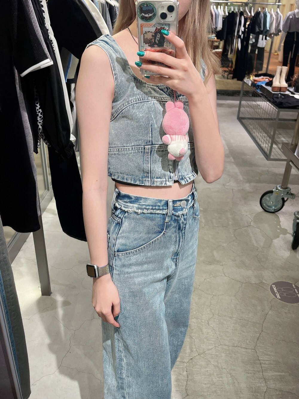 ブルー系のデニムパンツ、ブルー系のキャミソール、ブラック系のスニーカーを着用したレディースの春コーディネートの2枚目の写真