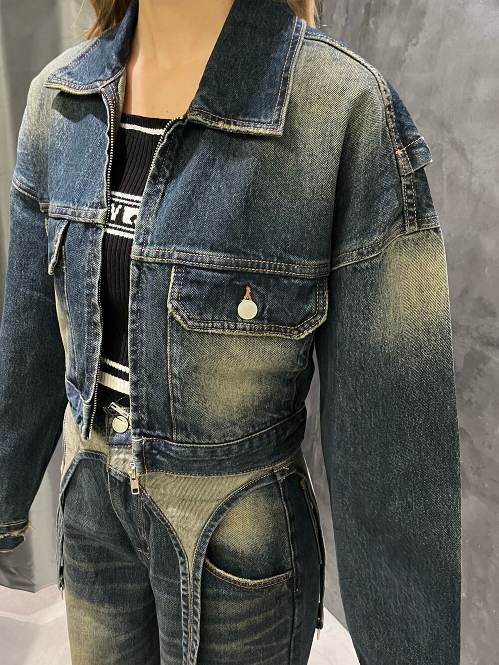 ブルー系のデニムパンツ、ブルー系のデニムジャケット、ブラック系のブーツを着用したレディースの秋コーディネートの4枚目の写真