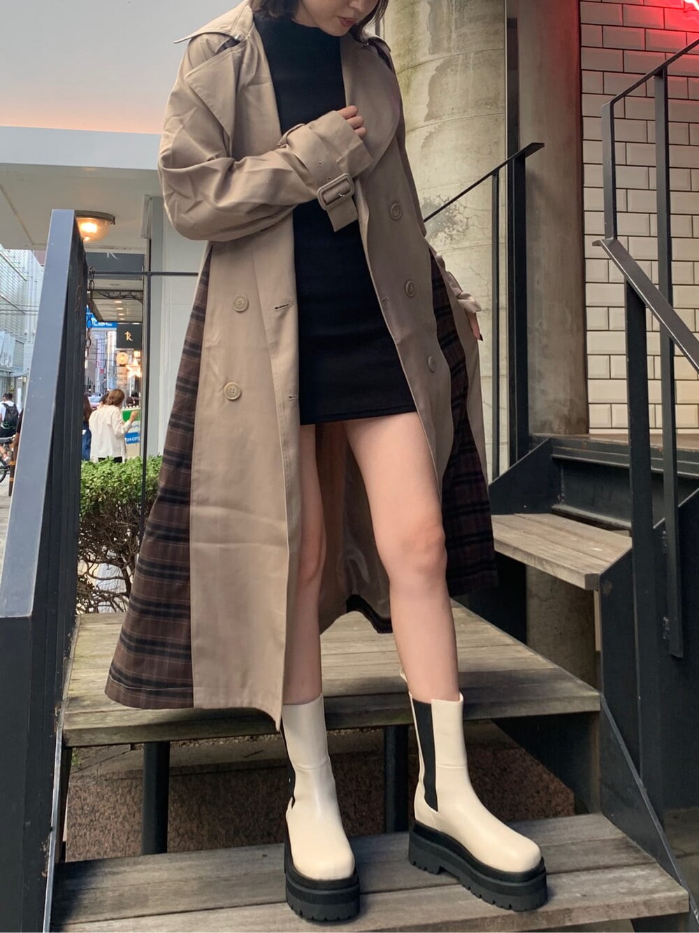 ベージュ系のトレンチコート、ブラック系のワンピースを着用したレディースの夏コーディネートの2枚目の写真