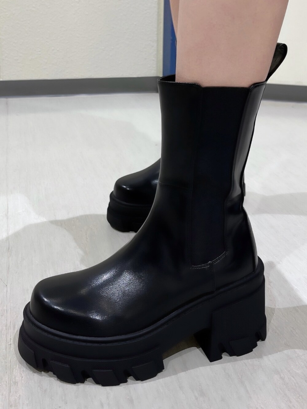 ブラック系のスカート、ブラック系のブルゾン、ブラック系のブーツを着用したレディースの夏コーディネートの6枚目の写真