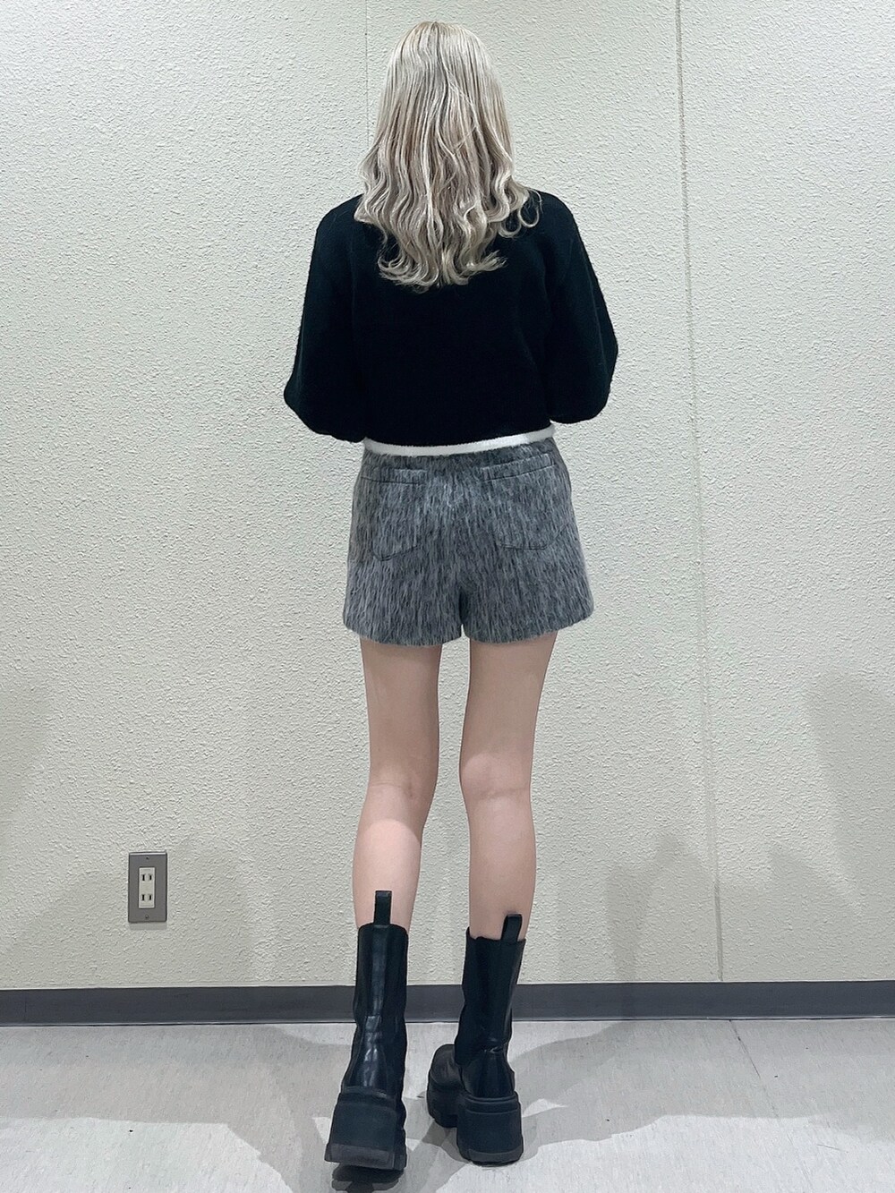 ブラック系のニット/セーター、グレー系のその他パンツ、ブラック系のブーツを着用したレディースの冬コーディネートの3枚目の写真