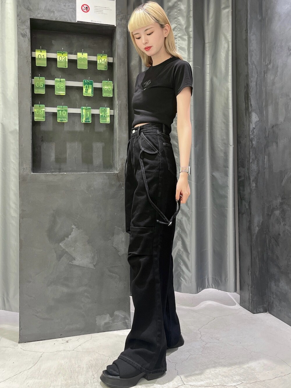 ブラック系のデニムパンツ、ブラック系のTシャツ/カットソー、ブラック系のサンダルを着用したレディースの夏コーディネートの2枚目の写真