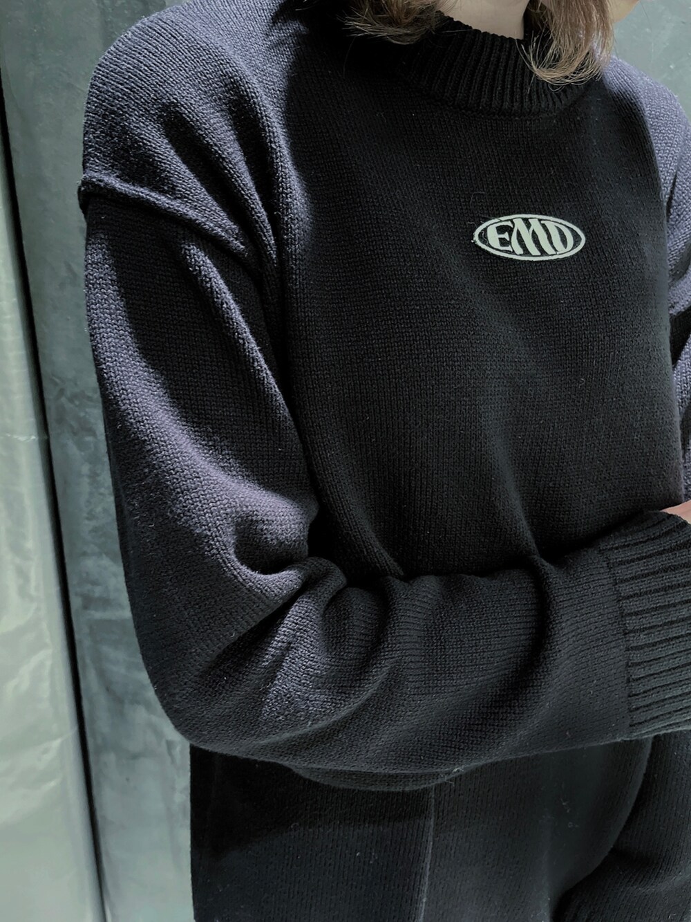 ブラック系のニット/セーター、ブラック系のブーツを着用したレディースの冬コーディネートの2枚目の写真