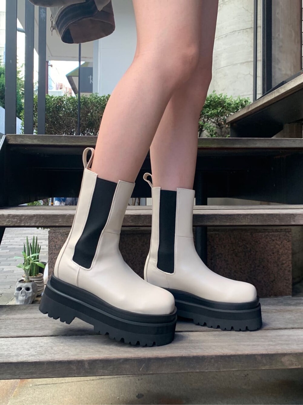 ベージュ系のトレンチコート、ブラック系のワンピースを着用したレディースの夏コーディネートの5枚目の写真