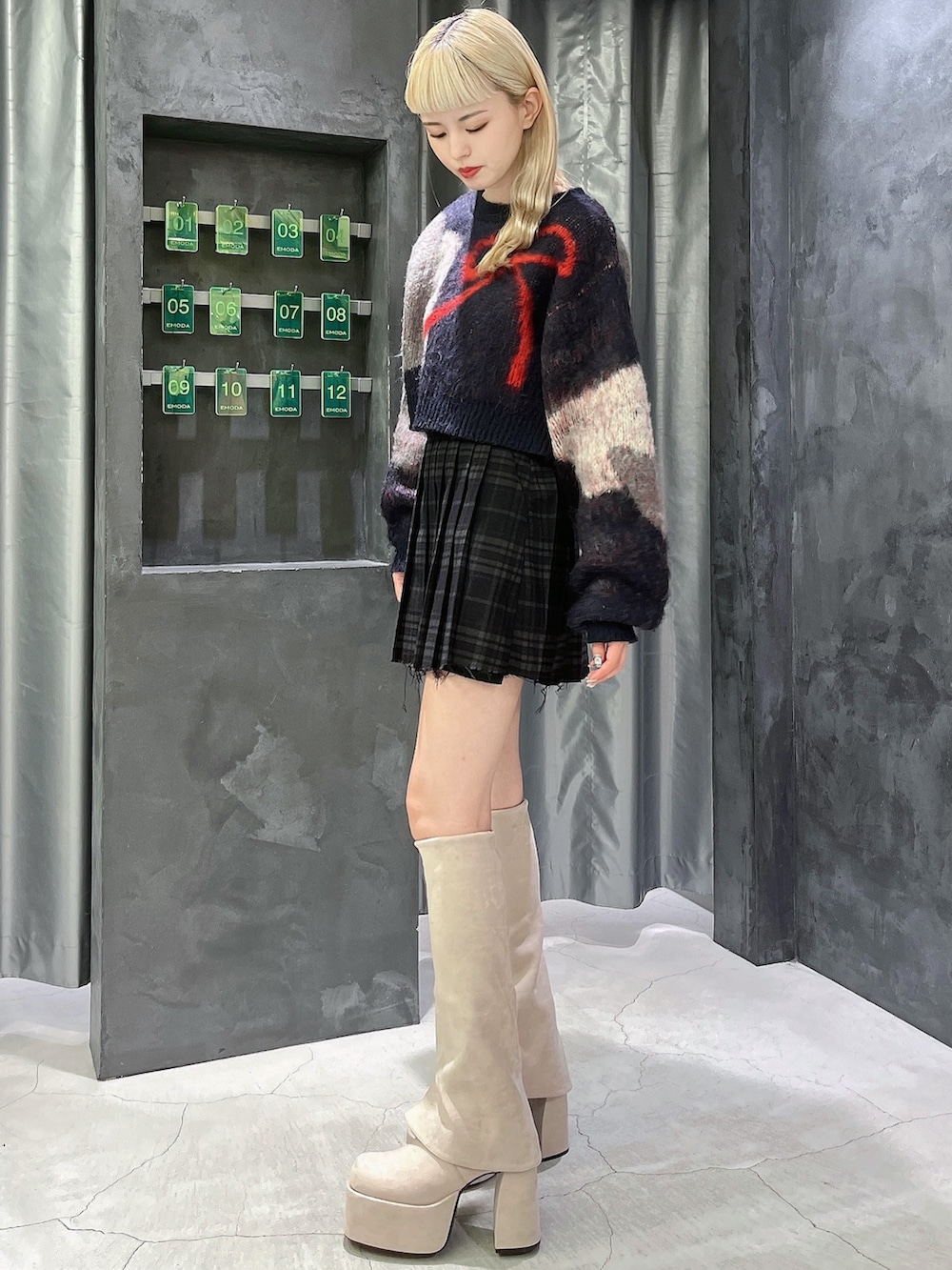 ブルー系のニット/セーター、その他のスカート、ホワイト系のブーツを着用したレディースの秋コーディネートの2枚目の写真