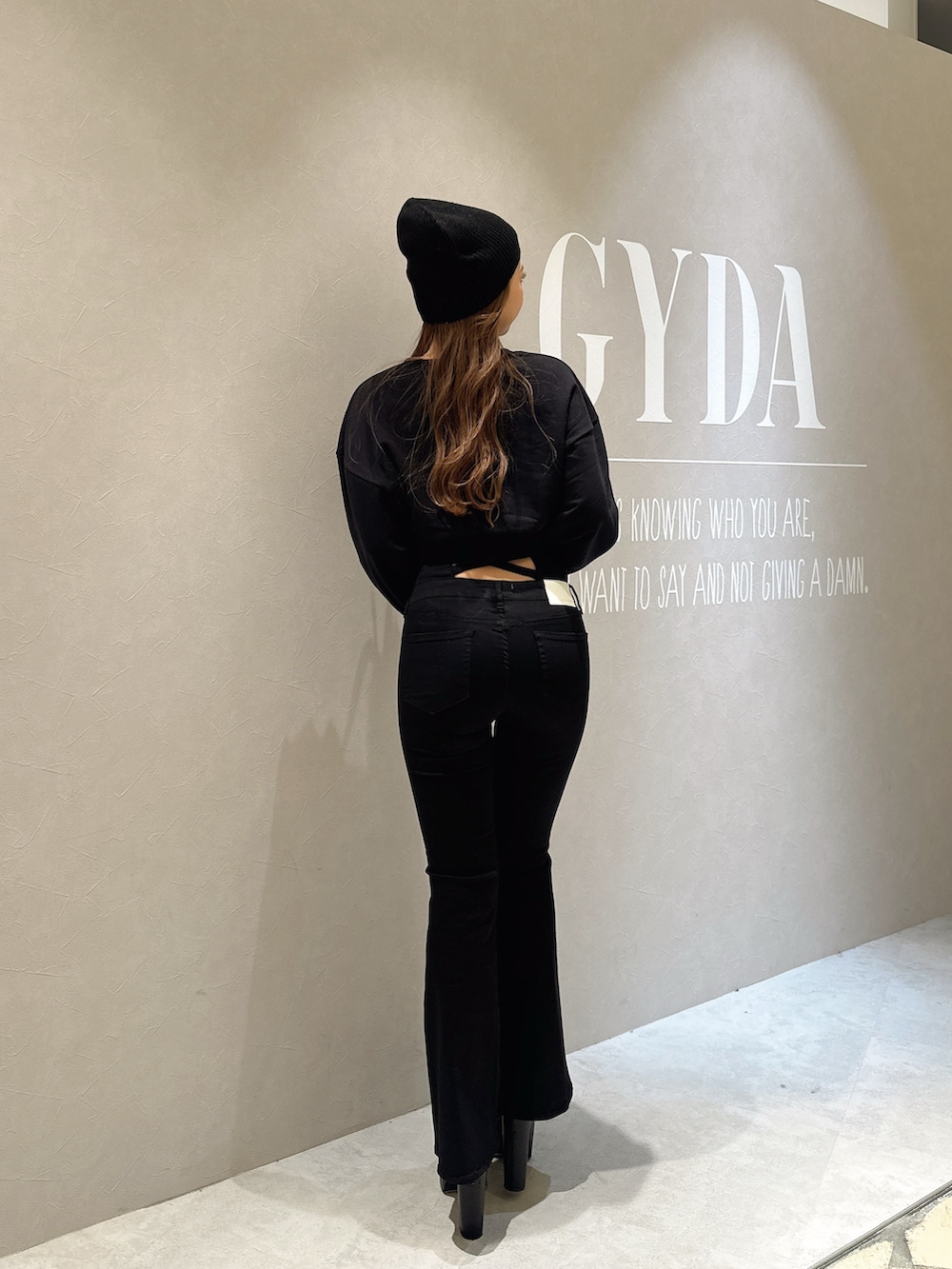 ブルー系のデニムパンツ、ブラック系のブーツ、ブラック系のスウェットを着用したレディースの冬コーディネートの2枚目の写真