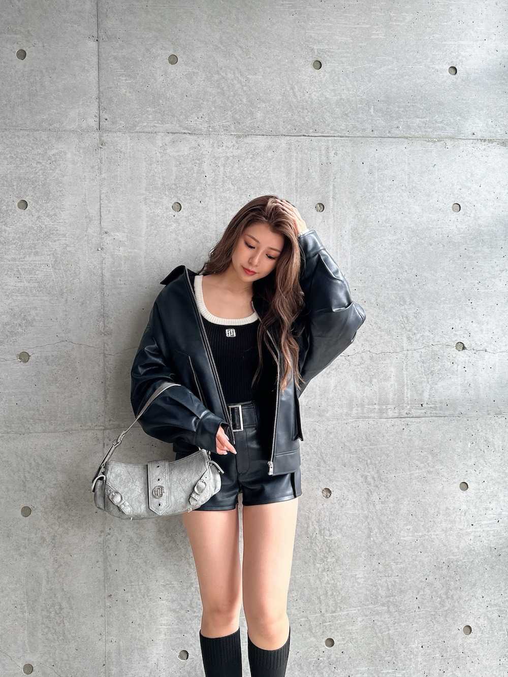 グリーン系のショルダーバッグ、ブラック系のブーツ、ブラック系のニット/セーターを着用したレディースの秋コーディネートの4枚目の写真