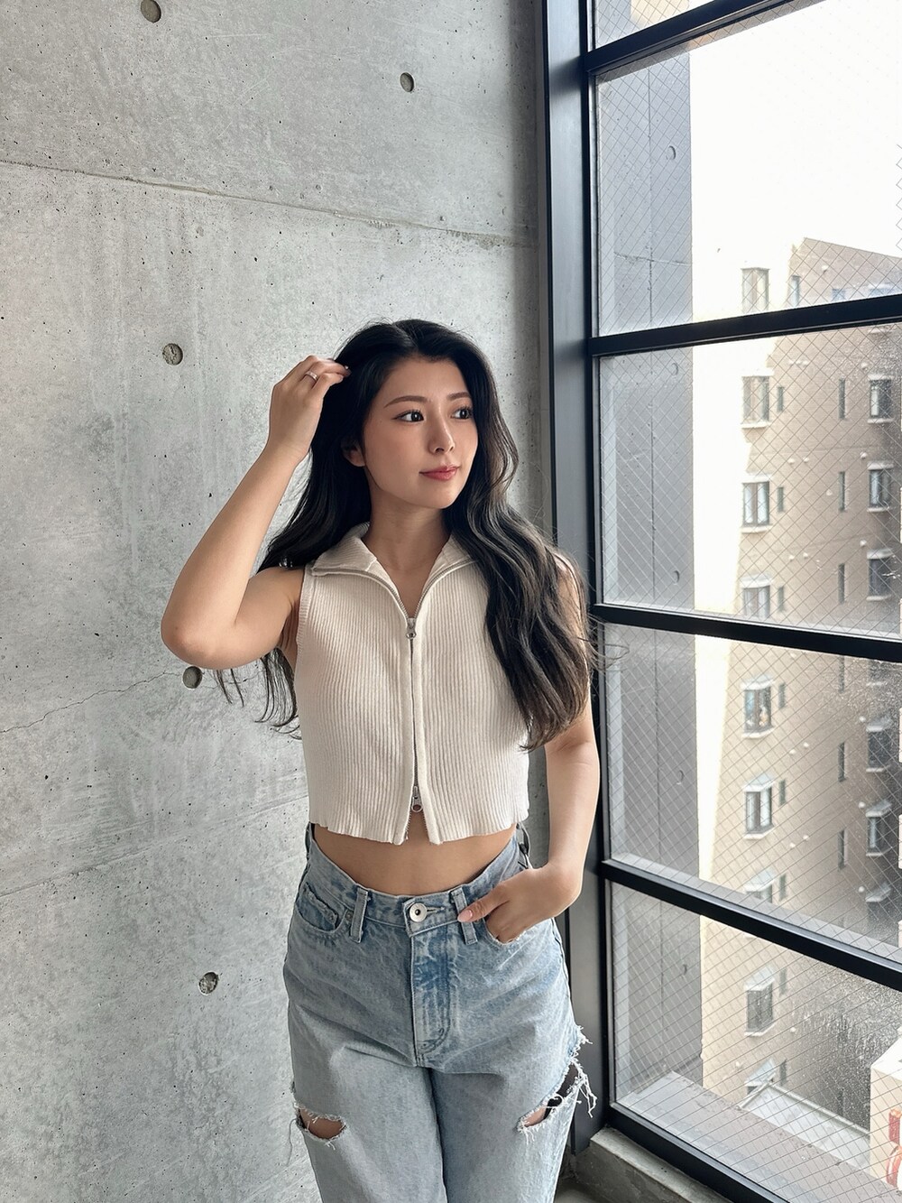 ホワイト系のパンプス、ホワイト系のタンクトップ、ブルー系のデニムパンツを着用したレディースの夏コーディネートの7枚目の写真