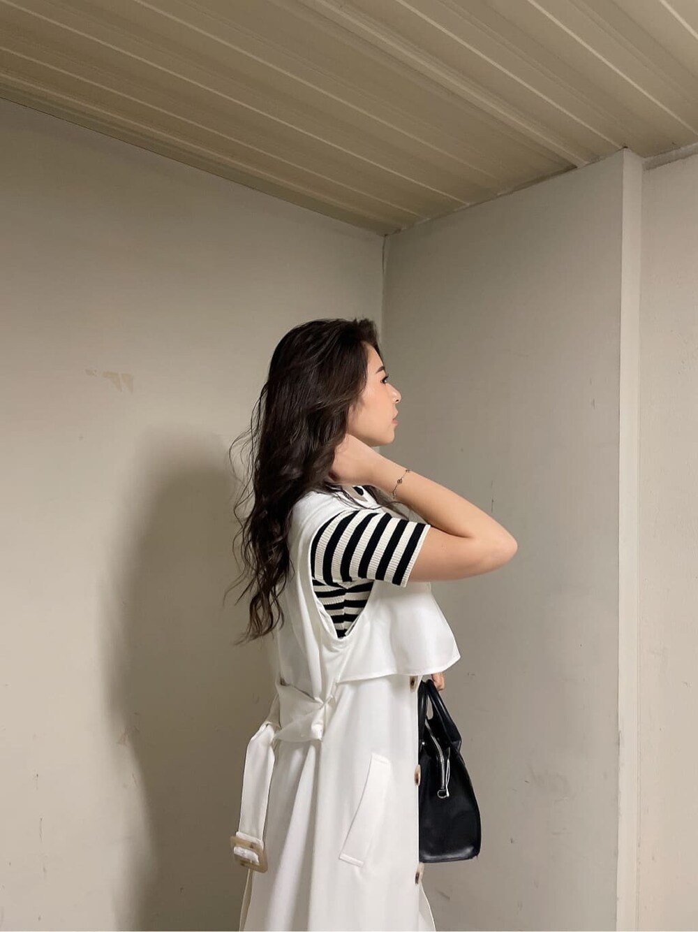 ホワイト系のトレンチコート、その他のワンピース、ブラック系のブーツを着用したレディースの春コーディネートの5枚目の写真