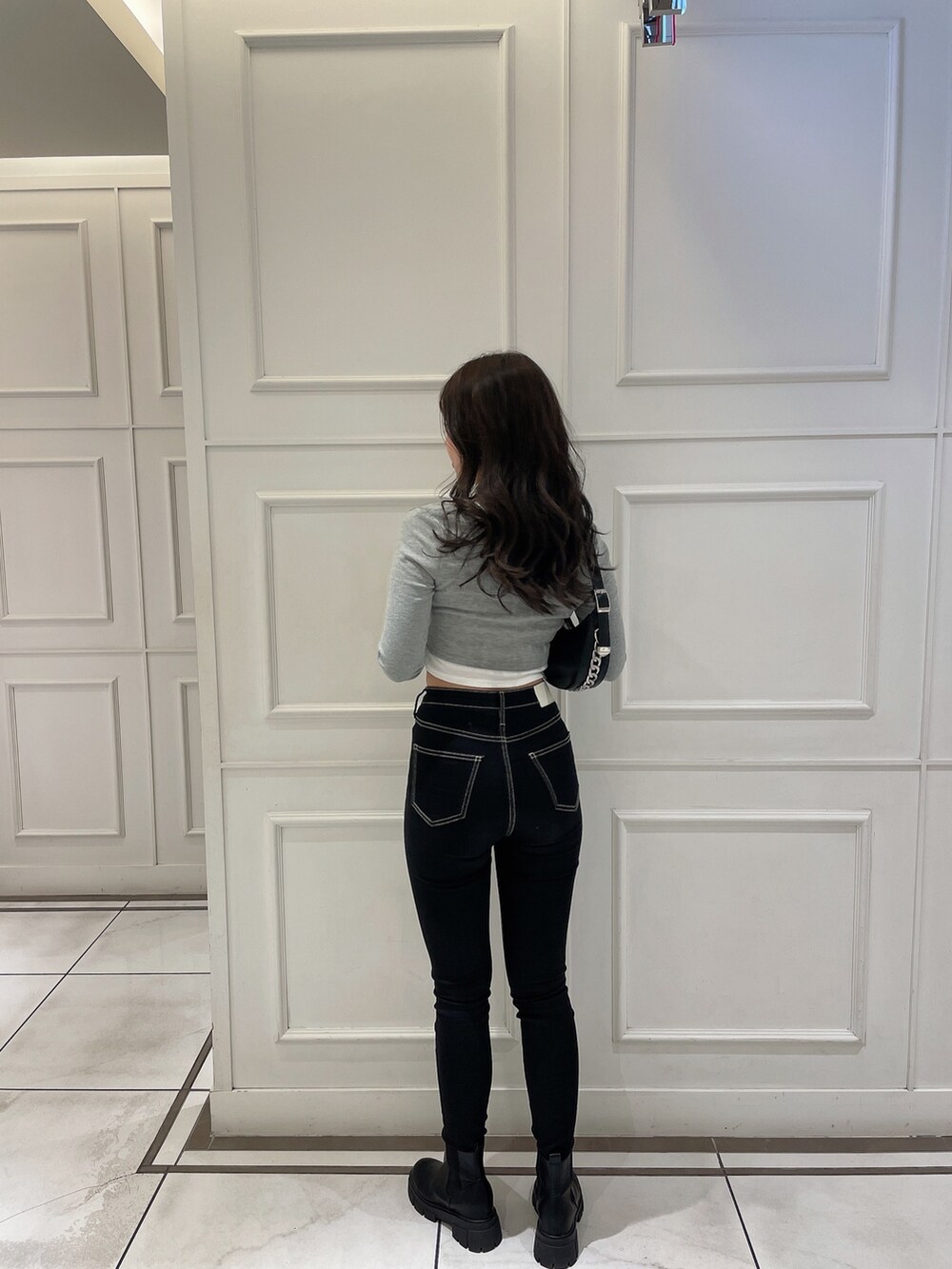 グレー系のTシャツ/カットソー、ブラック系のライダースジャケット、ブラック系のハンドバッグを着用したレディースの冬コーディネートの7枚目の写真