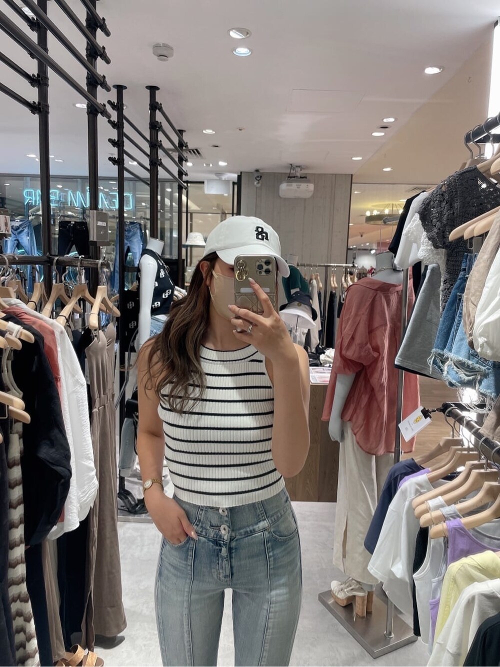 ホワイト系のサンダル、ホワイト系のタンクトップ、ブルー系のデニムパンツを着用したレディースの夏コーディネートの3枚目の写真