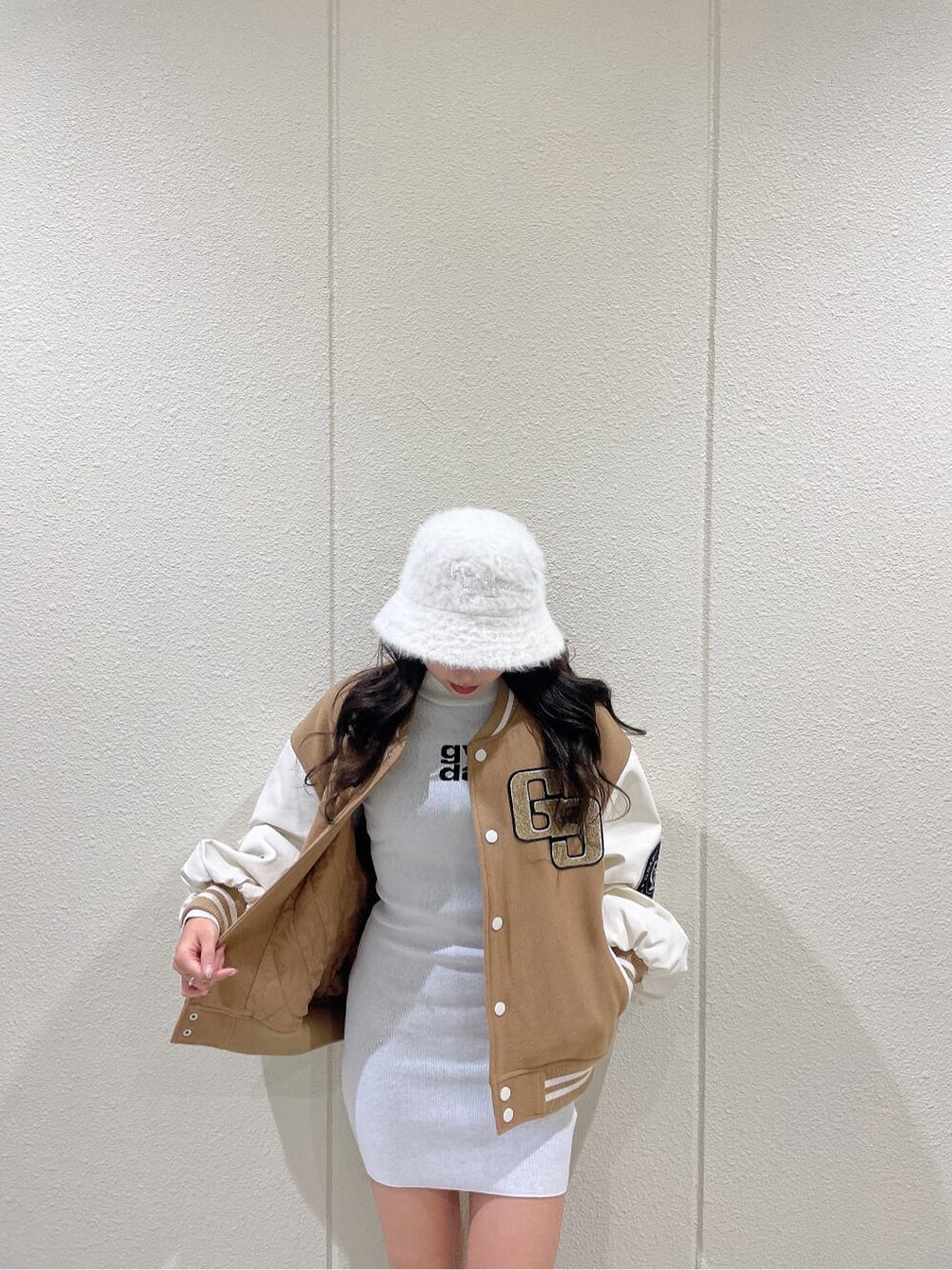 ベージュ系のスタジャン、ブラック系のブーツ、ホワイト系のワンピースを着用したレディースの秋コーディネートの6枚目の写真