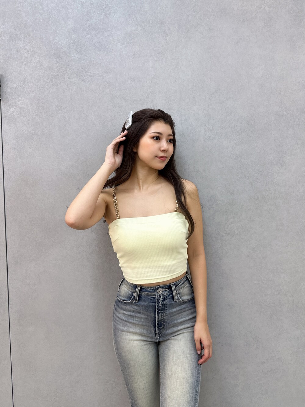 イエロー系のキャミソール、ホワイト系のシャツ/ブラウス、ブルー系のデニムパンツを着用したレディースの春コーディネートの5枚目の写真