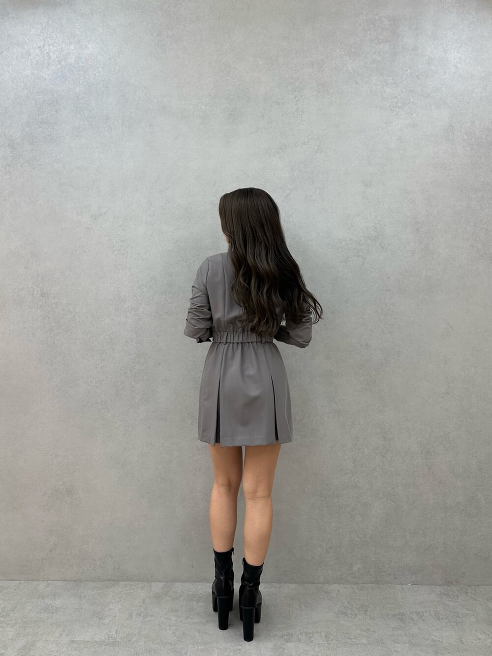 グレー系のワンピース、ブラック系のブーツを着用したレディースの秋コーディネートの3枚目の写真