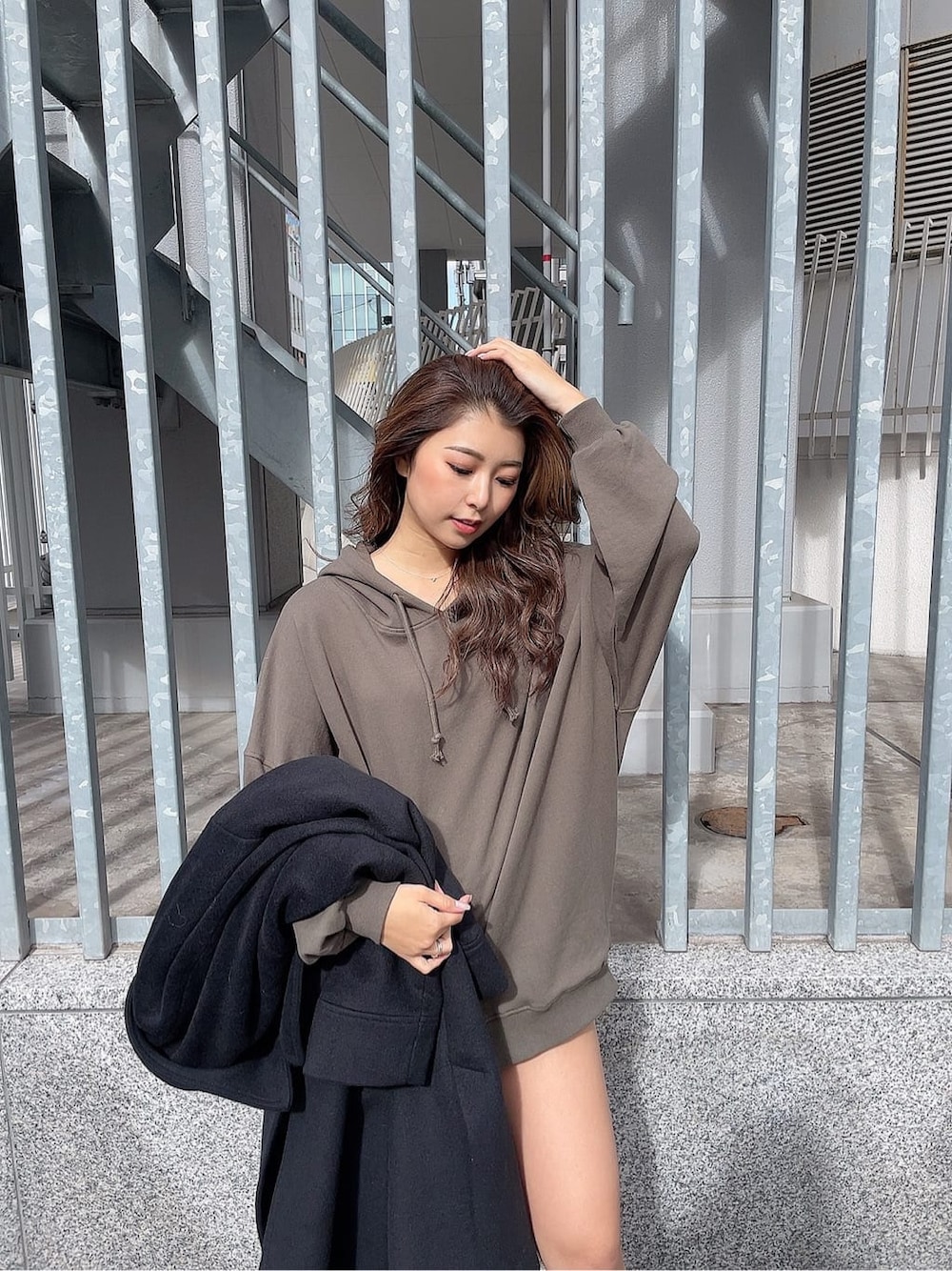 ブラック系のブーツ、ベージュ系のパーカー、ブラック系のチェスターコートを着用したレディースの秋コーディネートの5枚目の写真