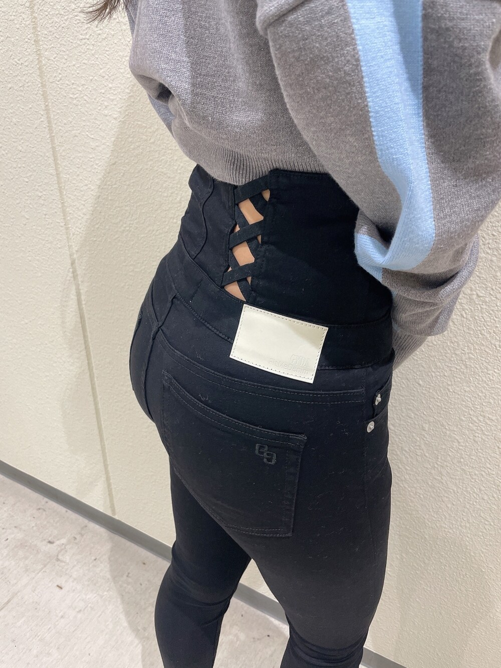 グレー系のニット/セーター、ブラック系のデニムパンツ、ホワイト系のパンプスを着用したレディースの冬コーディネートの7枚目の写真