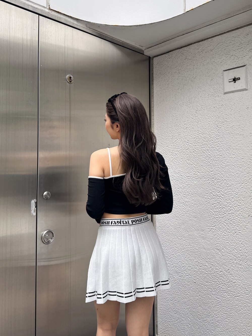 ホワイト系のスカート、ブラック系のTシャツ/カットソー、ブラック系のスニーカーを着用したレディースの冬コーディネートの4枚目の写真