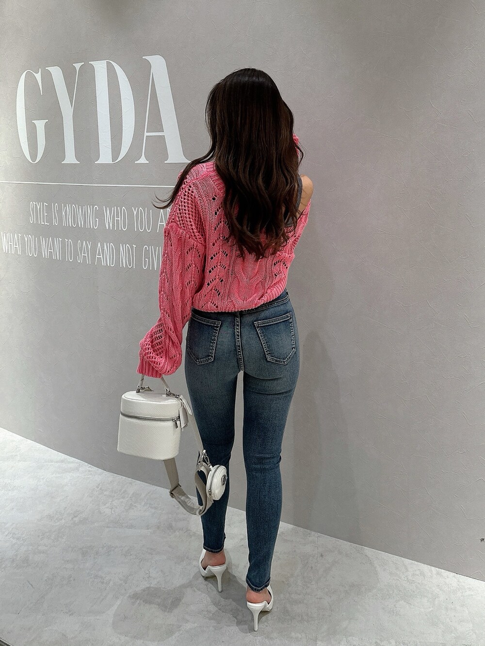 ピンク系のカーディガン/ボレロ、ブルー系のキャミソール、ホワイト系のハンドバッグを着用したレディースの春コーディネートの2枚目の写真