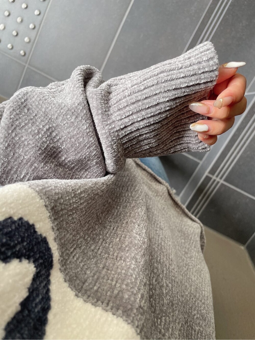ブルー系のデニムパンツ、ブラック系のブーツ、グレー系のニット/セーターを着用したレディースの秋コーディネートの10枚目の写真
