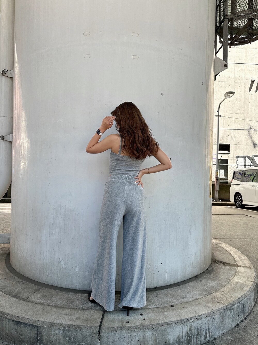 グレー系のキャミソール、ブラック系のスウェットパンツ、ブラック系のパンプスを着用したレディースの夏コーディネートの3枚目の写真