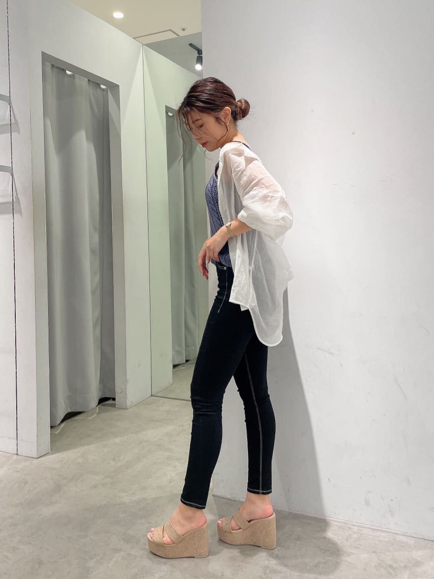 ブラック系のキャミソール、ブラック系のデニムパンツ、ホワイト系のシャツ/ブラウスを着用したレディースの春コーディネートの2枚目の写真