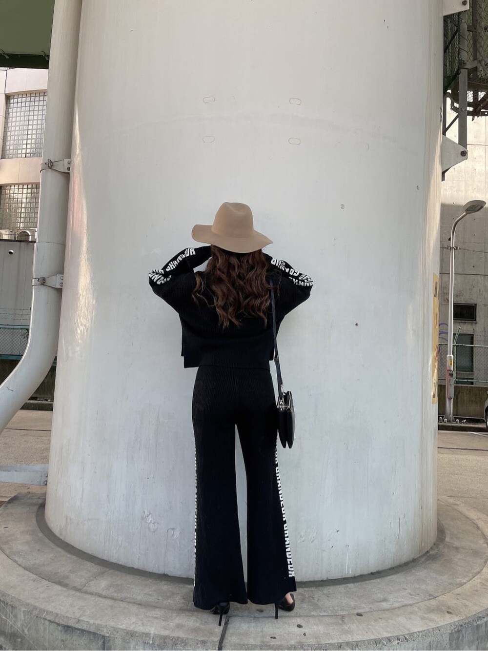 ブラック系のパンプス、ブラック系のニット/セーター、ブラック系のショルダーバッグを着用したレディースの冬コーディネートの4枚目の写真