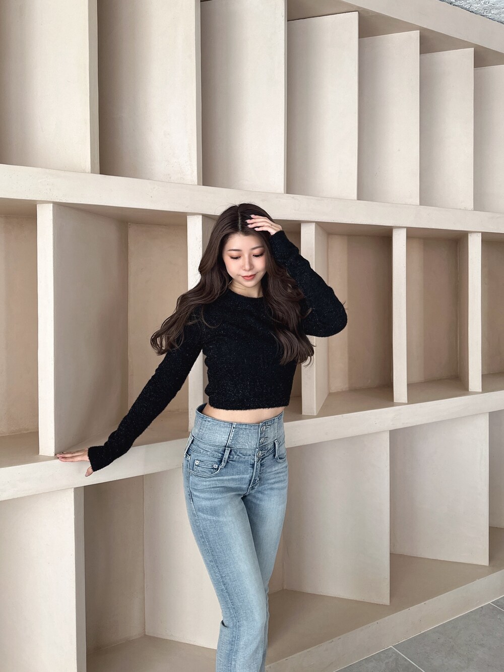 ブラック系のブーツ、ブルー系のデニムパンツ、ブラック系のニット/セーターを着用したレディースの秋コーディネートの4枚目の写真