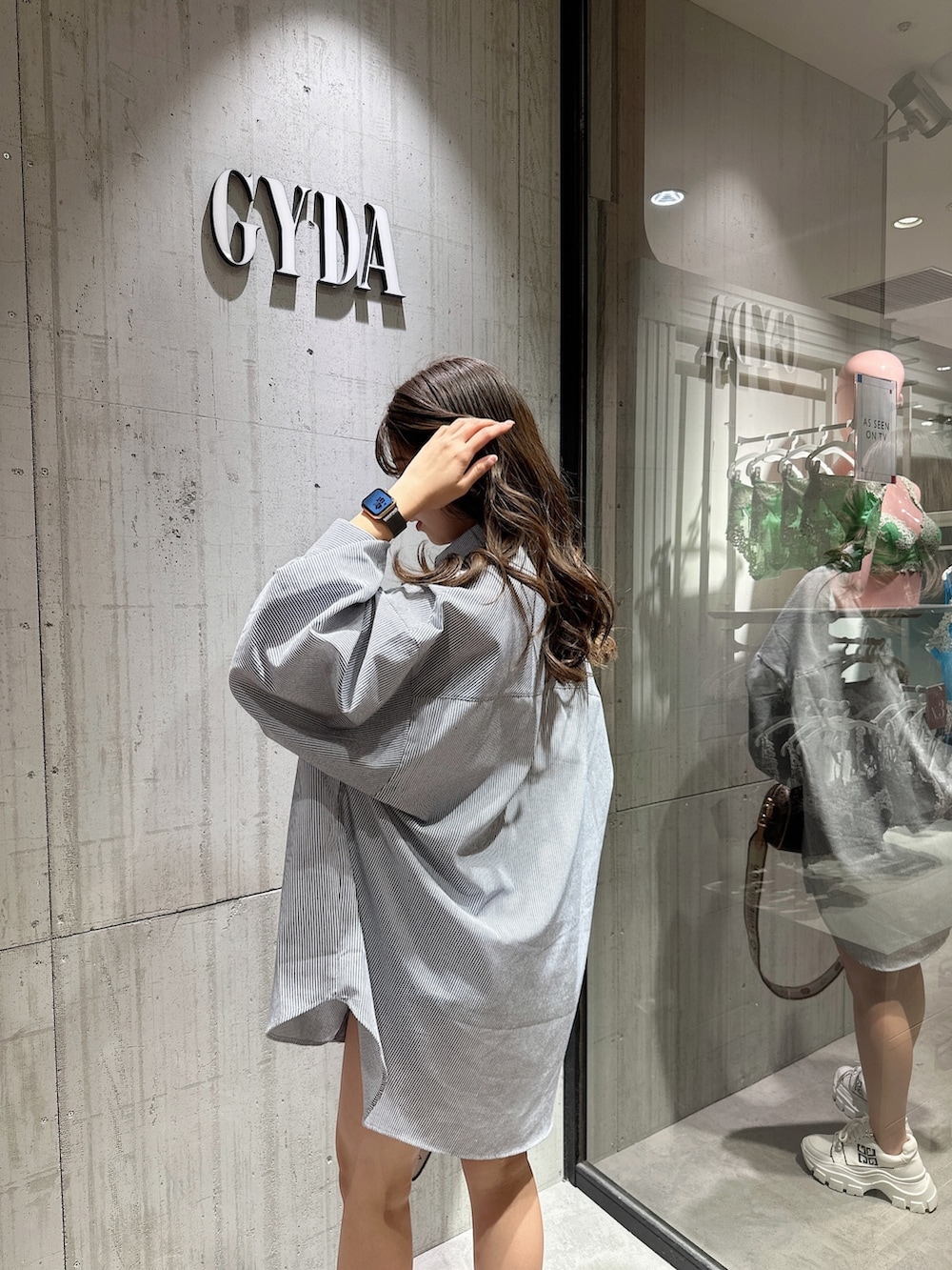 ブルー系のシャツ/ブラウス、ブラック系のスニーカーを着用したレディースの春コーディネートの6枚目の写真