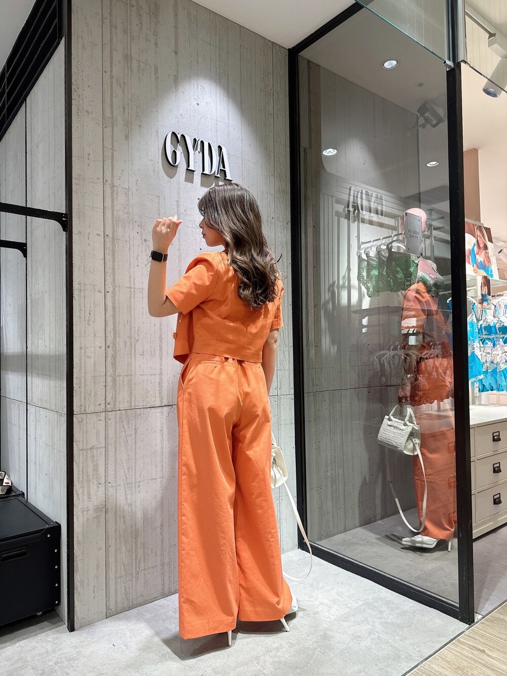 ホワイト系のTシャツ/カットソー、オレンジ系のテーラードジャケット、オレンジ系のスラックスを着用したレディースの春コーディネートの4枚目の写真