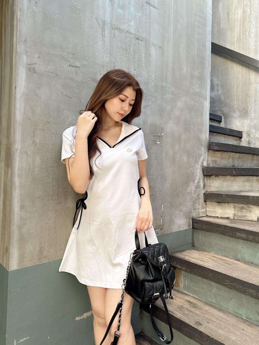 ホワイト系のワンピース、ブラック系のサンダル、ブラック系のバックパック/リュックを着用したレディースの夏コーディネートの4枚目の写真
