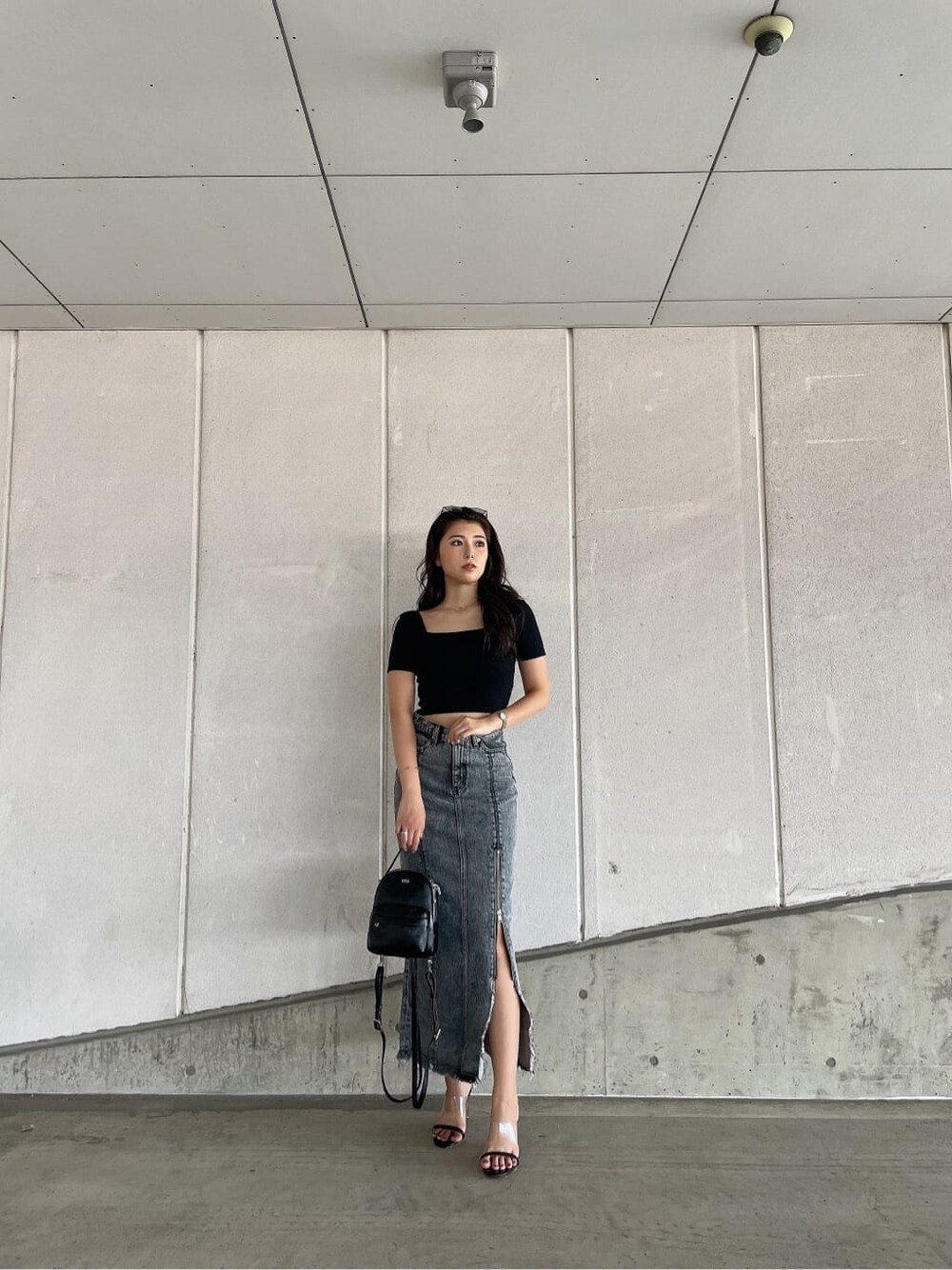 ブラック系のサンダル、ブラック系のバックパック/リュック、ブラック系のデニムスカートを着用したレディースの夏コーディネートの3枚目の写真