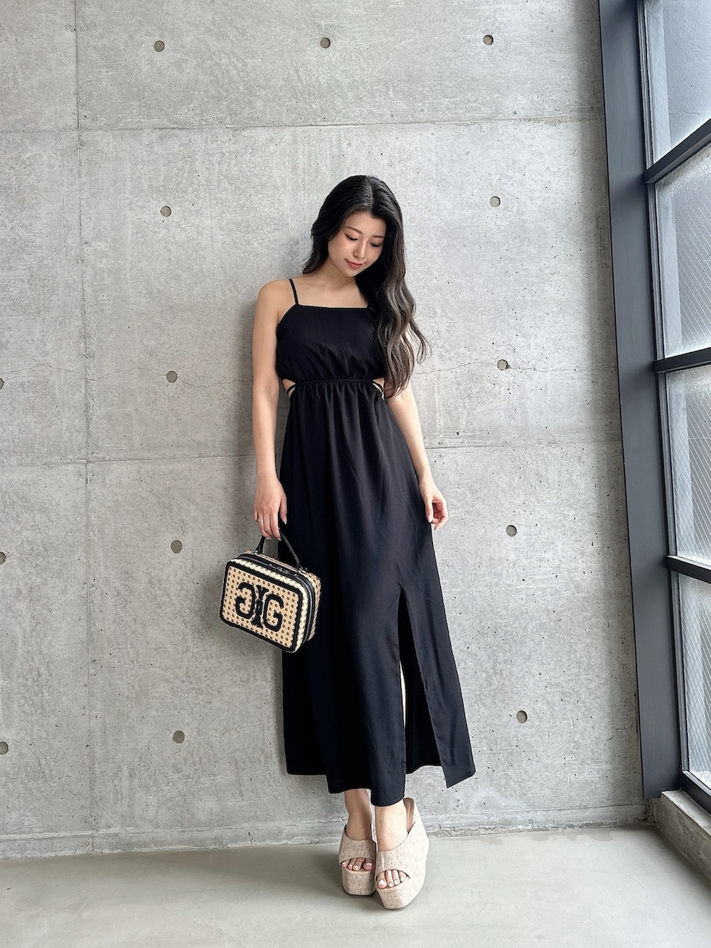 ホワイト系のサンダル、ブラック系のワンピース、ベージュ系のショルダーバッグを着用したレディースの夏コーディネートの2枚目の写真