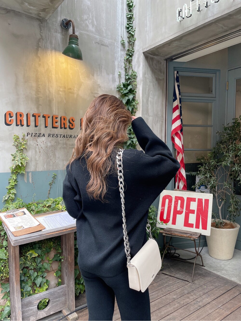 ホワイト系のショルダーバッグ、ブラック系のパンプス、ブラック系のその他パンツを着用したレディースの冬コーディネートの7枚目の写真