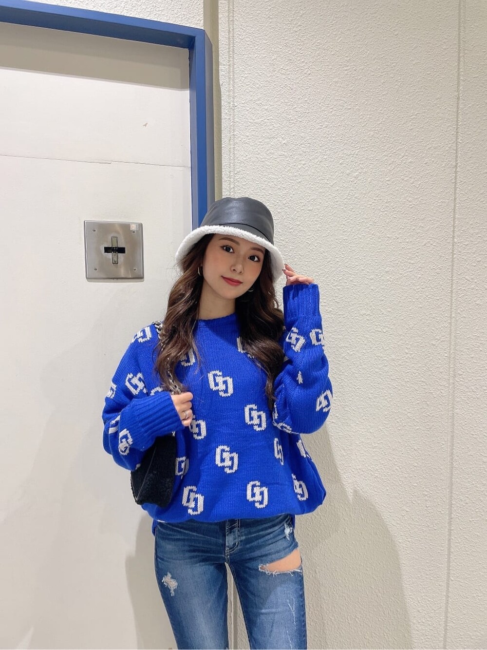 ブルー系のデニムパンツ、ブルー系のデニムパンツ、ブラック系のブーツを着用したレディースの秋コーディネートの4枚目の写真