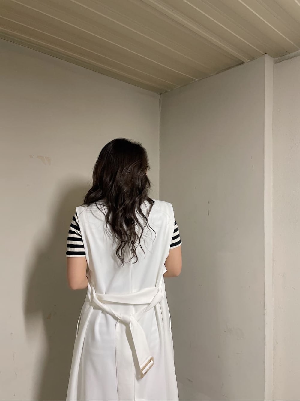 ホワイト系のトレンチコート、その他のワンピース、ブラック系のブーツを着用したレディースの春コーディネートの6枚目の写真