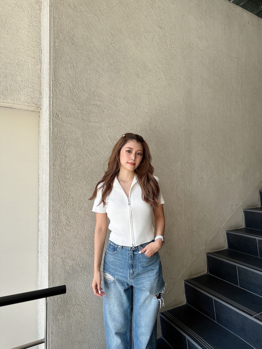 ホワイト系のニット/セーター、ブルー系のデニムパンツ、ブラック系のパンプスを着用したレディースの夏コーディネートの5枚目の写真