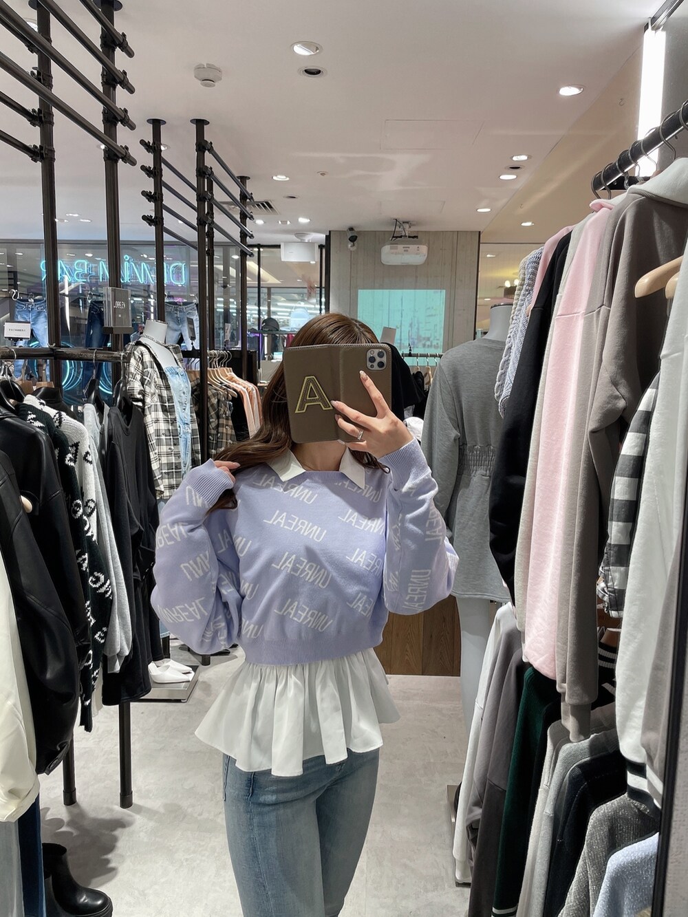 パープル系のニット/セーター、ホワイト系のシャツ/ブラウス、ブルー系のデニムパンツを着用したレディースの冬コーディネートの4枚目の写真