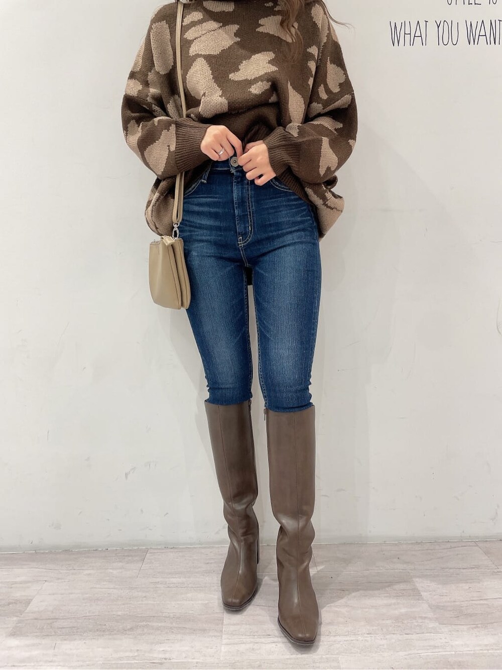 ブラウン系のブーツ、ブルー系のデニムパンツ、ベージュ系のショルダーバッグを着用したレディースの秋コーディネートの7枚目の写真