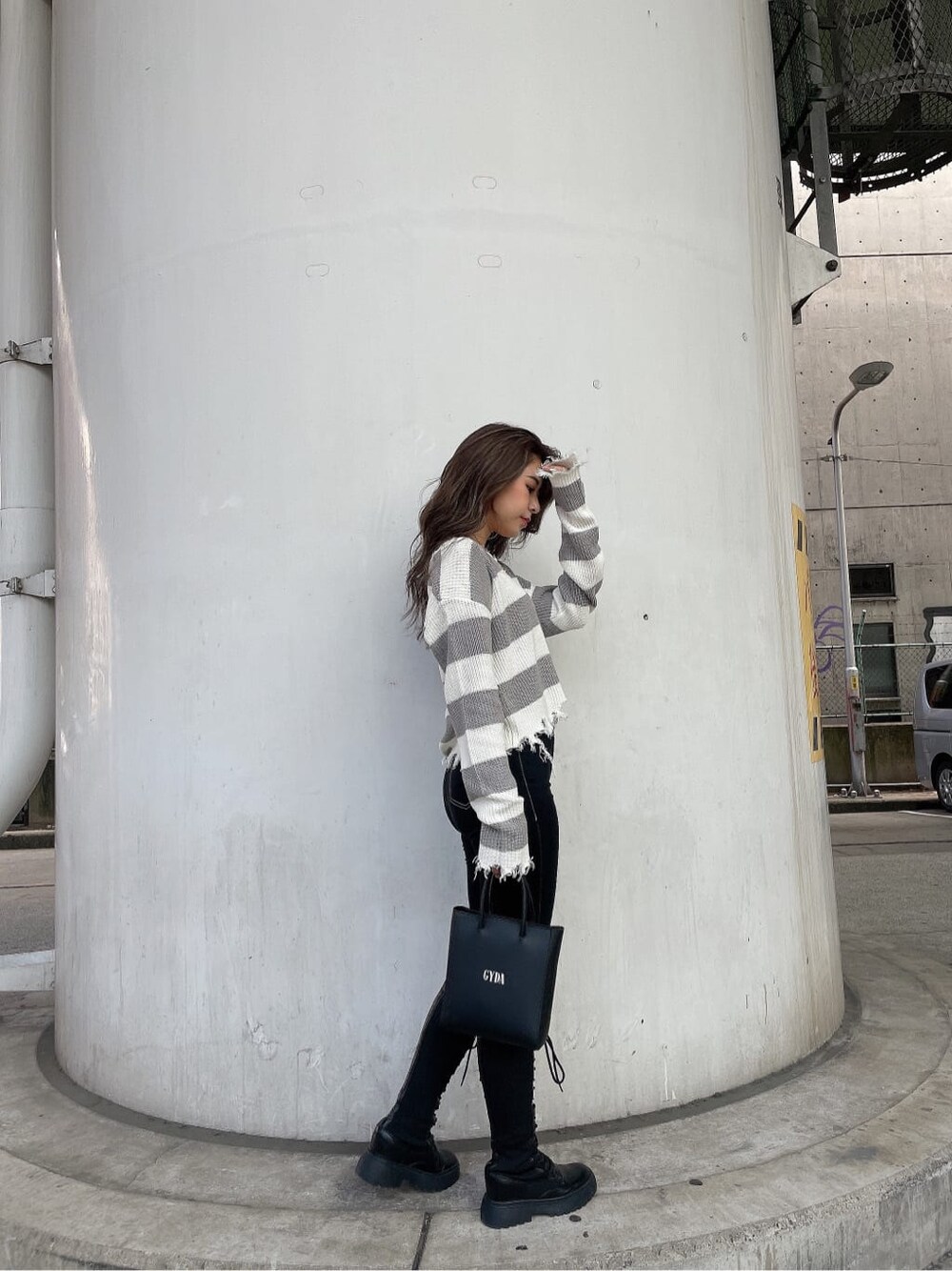 ブラック系のショルダーバッグ、ブラック系のデニムパンツ、グレー系のニット/セーターを着用したレディースの秋コーディネートの3枚目の写真