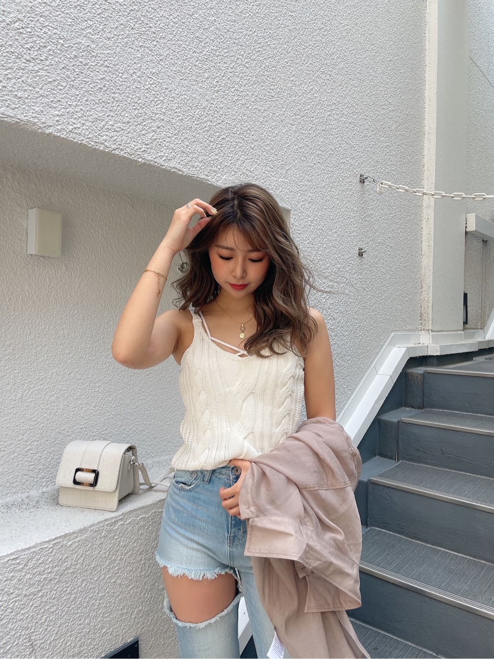 ホワイト系のキャミソール、ホワイト系のキャミソール、ブルー系のデニムパンツを着用したレディースの春コーディネートの5枚目の写真