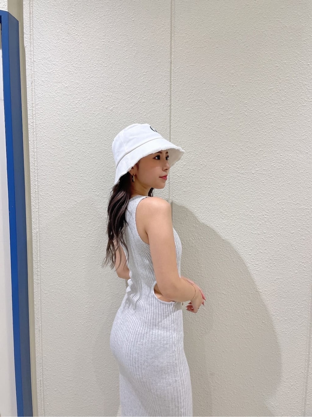 ホワイト系のサンダル、グレー系のワンピース、ホワイト系のハットを着用したレディースの夏コーディネートの5枚目の写真