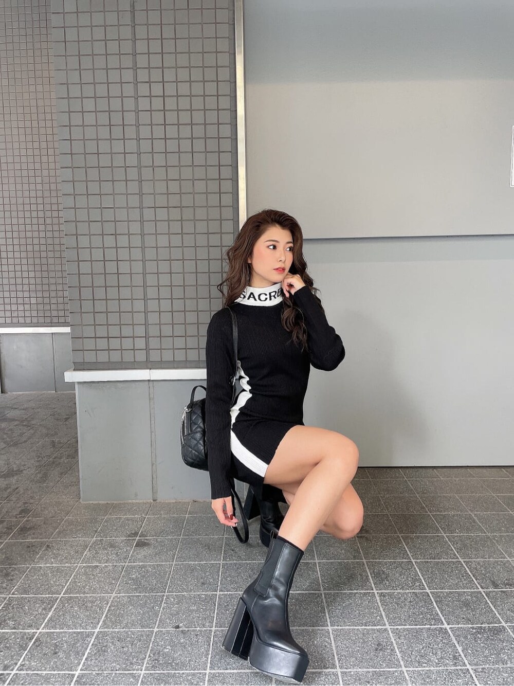 ブラック系のブーツ、ブラック系のバックパック/リュック、ブラック系のワンピースを着用したレディースの秋コーディネートの3枚目の写真